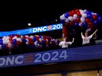 Workers set up balloons before they are lifted above the floor of the United Center for the DNC on Friday in Chicago. The official programming begins Monday.