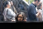 Lily Palaourbina, 8, peeks into Hidden Worlds bookstore while waiting in line with her family on Saturday, Sept. 19, 2026.
