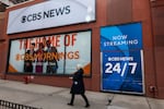 People walk by the CBS Broadcast Center in Manhattan on March 20, 2026 in New York City. CBS News and CNN are merging as part of the Paramount and Warner Bros. acquisition.