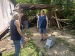 Shelly Sweeney (right) smiles as she reunites Cindy McCarthey (left) with her cat Rambo on Thursday, after he ran off during the catastrophic flooding in central Texas last week. Rambo had been missing for almost a week.