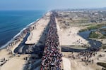 This aerial photo shows displaced Gazans walking toward Gaza City on Jan. 27, 2025, after crossing the Netzarim corridor from the southern Gaza Strip.