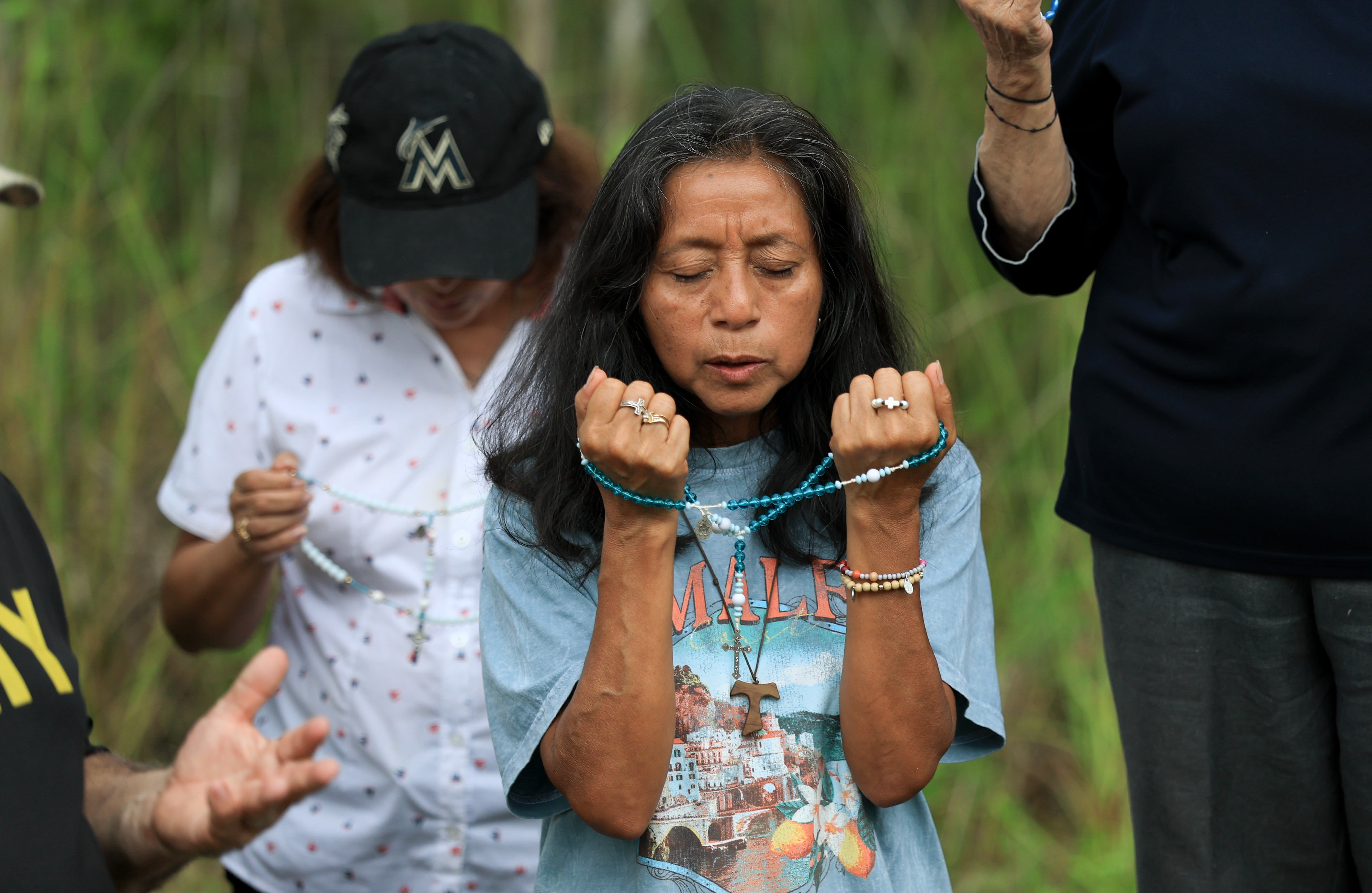 Marina Paz prays near the entrance to