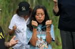 Marina Paz prays near the entrance to "Alligator Alcatraz" at the Dade-Collier Training and Transition Airport in Ochopee, Fla., on July 12.