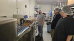 Robert Ehrmentrout, right, watches as two Euphoria chocolate employees make chocolate-dipped cookies.