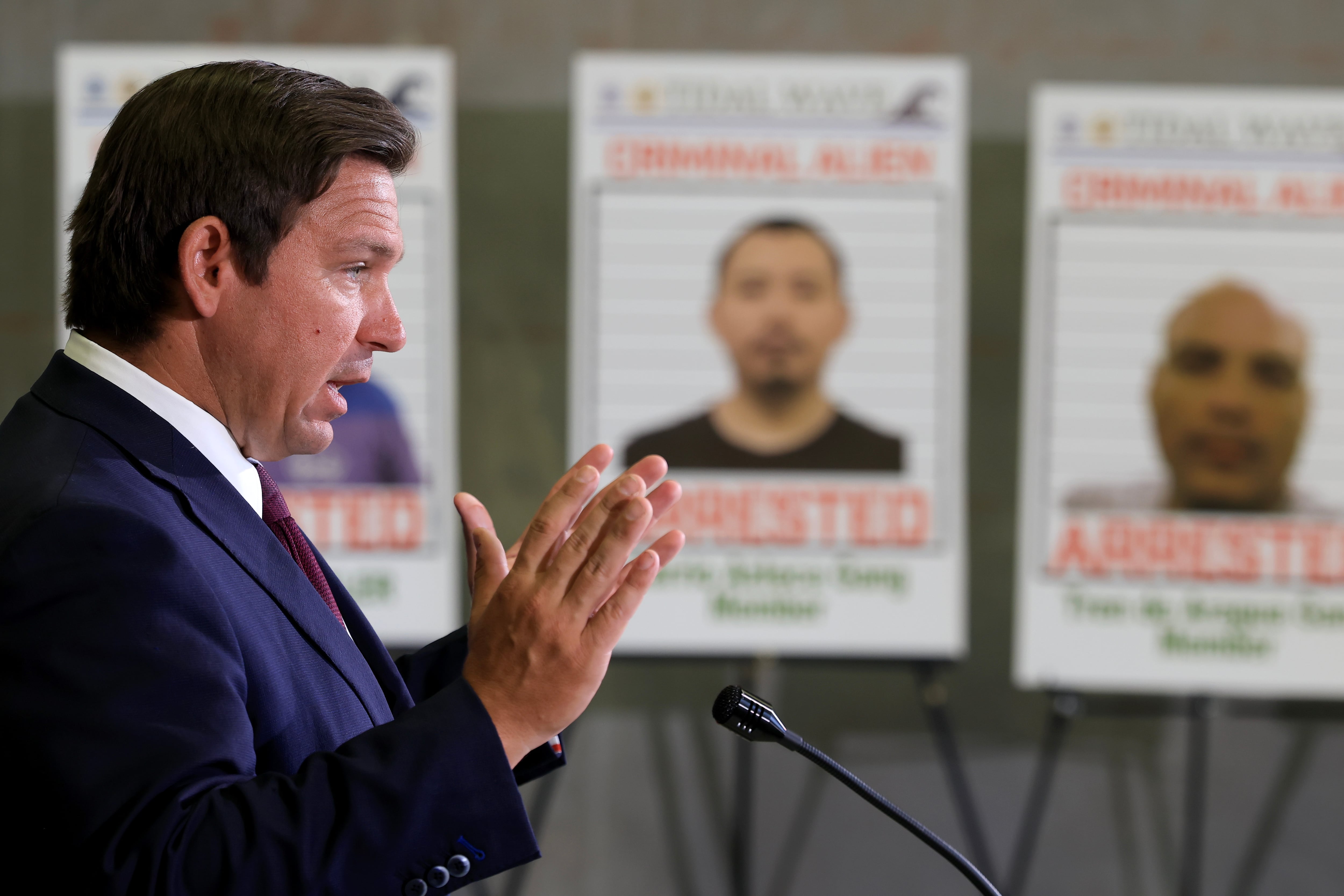 Florida Gov. Ron DeSantis speaks during a press conference in front of posters of people that law enforcement arrested, held at the ICE Enforcement and Removal Operations office on May 1, 2025 in Miramar, Fla. Florida has issued its own financial incentives to encourage more local police cooperation with ICE.