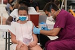 FILE - Francesca Anacleto, 12, receives her first Pfizer COVID-19 vaccine shot from nurse Jorge Tase, Wednesday, Aug. 4, 2021, in Miami Beach, Fla. In most states, minors need the consent of their parents in order to be vaccinated against COVID-19. Navigating family politics in cases of differing views has been a challenge for students and organizers of outreach campaigns, who have faced blowback for directly targeting young people.