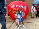 4-year-old Olivia Person stands outside Charles City Elementary on her first day of school with her 2-year-old sister Aria.