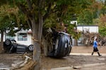 ASHEVILLE, NORTH CAROLINA - OCTOBER 01: A man walks past damaged vehicles at the Biltmore Village across from the Biltmore Estate in the aftermath of Hurricane Helene on October 1, 2024 in Asheville, North Carolina. According to reports, at least 140 people have been killed across the southeastern U.S., and millions are without power due to the storm, which made landfall as a Category 4 hurricane. The White House has approved disaster declarations in North Carolina, Florida, South Carolina, Tennessee, Georgia, Virginia and Alabama, freeing up federal emergency management money and resources for those states. (Photo by Melissa Sue Gerrits/Getty Images)