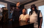 Ebony Everson (center), Bobby Everson's sister, stands with her father, who is also named Bobby Everson, and her mother Sabrina Everson. Photos of their son Bobby are on the wall behind them.