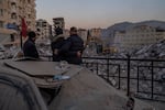 Men observe the site of collapsed buildings during the earthquake in Antakya, southeastern Turkey, Tuesday, Feb. 14, 2023. The death toll from the earthquakes of Feb. 6, which struck Turkey and northern Syria is still climbing. 