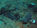 This 2004 photo shows the remains of a coat and boots in the mud on the sea bed near the Titanic's stern.