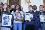 Family members of people who were killed in the midair collision near Ronald Reagan Washington National Airport hold portraits of their loved ones as they stand and listen during a news conference ahead of a vote on an aviation safety bill on Capitol Hill.