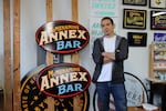 Nick Lee stands next to his latest project, a sign for McMenamins Annex Bar. Studio Signs Co. has been painting all of the signs for McMenamins.