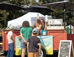 Emily Glock hands a shaved ice to a customer on Aug. 5, 2026, at the Baker County Fairgrounds in Baker City, Ore.