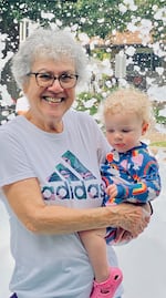 Michael Sweet's mother, Donna Sweet, holds her 18-month-old great-granddaughter, Margot Higgins, during a family event celebrating her wedding anniversary.