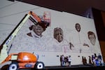 The artists and organizers of the mural, "Never Look Away," stand in front of its to-scale projection on the first day of production.