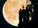 The first supermoon of the month rises behind angel sculptures on St. Isaac's Cathedral in St. Petersburg, Russia. The next lunar spectacle, a blue supermoon, will take place on Aug. 30.