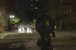 A person bicycles away from police during a protest against police brutality and systemic racism in Portland, Ore., July 4, 2020.