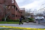 FILE - A Portland police officer walks at the scene of a U.S. Border Patrol shooting of two people in Portland, Ore., on Jan. 8, 2026.