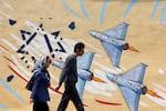 Iranians walk past a mural against Israel and the U.S., in Tehran, Iran, on Tuesday.
