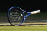 FILE - A tennis racket sits on the court at the Wimbledon Tennis Championships in London, July 11, 2026.