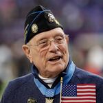 Woody Williams assists with the coin toss before Super Bowl 52 in February 2018 in Minneapolis. Williams, the last remaining Medal of Honor recipient from World War II, died Wednesday at 98, at the Veterans Affairs medical center bearing his name in Huntington, W.Va.