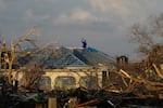 A man searches for cell signal from the roof of his house flooded and damaged by Hurricane Melissa in Black River, Jamaica, on Thursday.