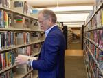 Nate Coulter, executive director of the Central Arkansas Library System (CALS), looks at a book in the main branch of the public library in downtown Little Rock, Ark., on May 23, 2023. Arkansas is temporarily blocked from enforcing a law that would have allowed criminal charges against librarians and booksellers for providing "harmful" materials to minors, a federal judge ruled Saturday, July 29.