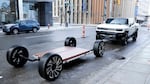 A battery pack and a GMC Hummer EV stand outside an event in Lansing, Mich., in 2022. Thea Riofrancos says car shoppers concerned about the environmental impacts of mining for batteries can choose a smaller EV, instead of a behemoth like a Hummer, to minimize the harms.