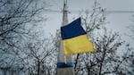A Ukrainian flag adorns an electrical post in Kupiansk, in the Kharkiv region, on Feb. 13, nearly a year after the Russian invasion of Ukraine.