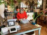 Ashley Preece, owner of Glasshaus Gardens plant shop in Southeast Portland, gets a delivery order ready on Nov. 17, 2023. She's had to cut the shop's hours due to the Portland Public Schools teachers strike.