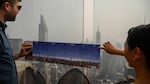Heavy smoke from Canada's wildfires has put a thick haze over large parts of the U.S. this summer. Here, visitors to New York City hold a map showing city landmarks on a clear day as they stand on the viewing deck of Rockefeller Center in late June.