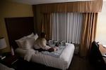 Claire and her 5-month-old son play on a bed at a Comfort Inn and Suites near downtown Vancouver. Claire spent three weeks living out of the hotel as she tried to get her husband help during a mental health break.