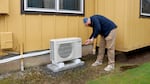 Alpine Heating & Air Conditioning General Manager Cody Calavan is inspecting a heat pump unit he installed at an affordable housing property owned by St. Vincent de Paul. The company secured funding through the Oregon Rental Heat Pump Program to install more than 520 heat pump units in the Eugene area. Pictured on March 27, 2025.