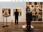 Two people spend time with different art pieces during the “Citizen Fellow: Art as Archive and Memory” exhibition opening at the Center for Native Arts and Cultures on Sept. 19, 2024.