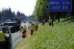 Workers clean garbage off the side of a highway in this undated photo provided by Interstate Business Solution.