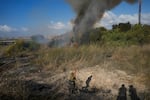 A police officer inspects the area around a fire after the military said it fired interceptors at a missile launched from Yemen that landed in central Israel on Sunday, Sept. 15, 2024.