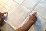 Longtime volunteer historian at Chemawa Indian School, SuAnn Reddick, points out burial sites on a grid, which maps out what's known about unmarked graves at the Chemawa cemetery, in July 2021.