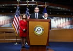 Speaker Mike Johnson, R-La., addresses reporters as Rep. Lisa McClain, R-Mich., and Majority Leader Steve Scalise, R-La., look on during a news conference Tuesday ahead of the government funding vote.
