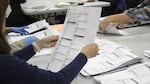 A worker examines a ballot at the Clackamas County elections office on May 19, 2022, in Oregon City, Ore. No Labels, a centrist group that has floated a bipartisan presidential ticket, has secured access to the ballot in Oregon and other states.