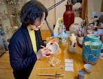 Artist and conservator Naoko Fukumaru, shown here in a provided photo, applies gold powder to a kintsugi artwork in her Vancouver studio, 2024. Fukumaru's first solo kintsugi exhibit in the U.S. will be on display at the Portland Japanese Garden through Jan. 27, 2025.