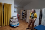 Kimberly Kimble stands in front of three makeshift bedrooms, sectioned off by room dividers, in her family's studio apartment in Portland, Ore., on Sept. 26, 2024. Kimble was told she was moving into a three-bedroom apartment when she signed the lease in 2021.