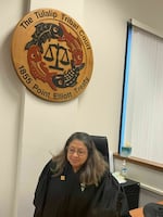 Tulalip Tribal Court Chief Judge Meredith Drent takes a seat below the court's official seal, which depicts four salmon encircling the scales of justice.