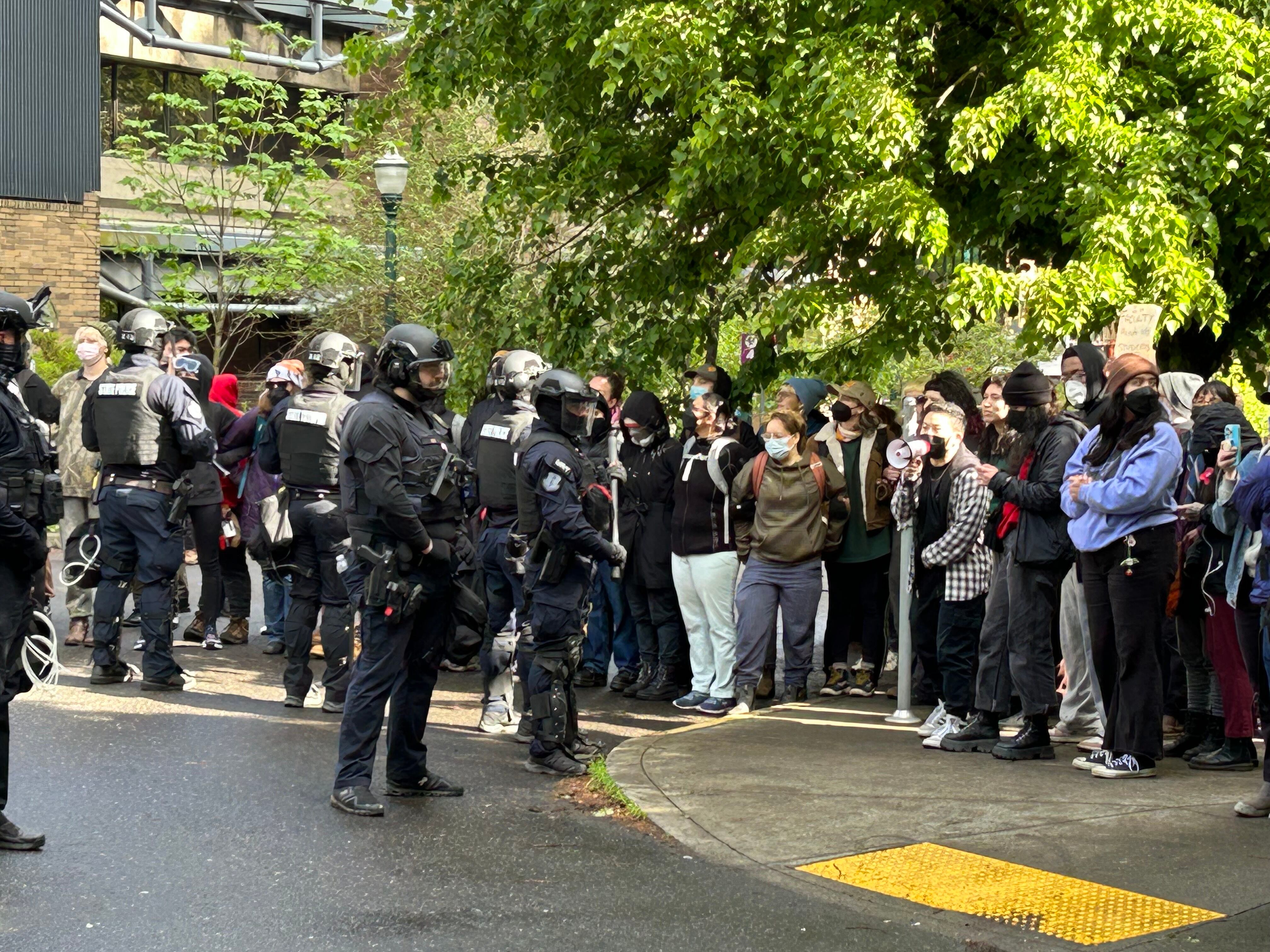 Protesters line up near corner of Southwest Montgomery Street and Southwest 10th Avenue in downtown Portland, Ore., on Thursday, May 2, 2024, to block the passage of a van carrying detained protesters.