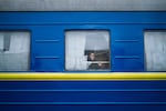 A girl looks out the window of a train leaving the station in Lviv for Poland after waving farewell to her father last March.