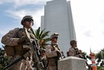 Three Marines holding large firearms stand guard at an entrance to the Wilshire Federal Building in Los Angeles on June 13, 2025.