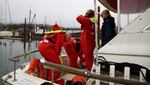 Deck hands try to put on their survival suits in a drill. The Coast Guard wants them to do it in less than a minute because a boat can sink in as little as two minutes.