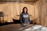 Cheryl Antonsic stands next to huge paella cookers.