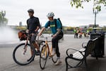 Florin Veja, left, and Abby McFeeters-Krone get on their bikes to continue commuting to Nike, where they work, after participating in the bike bus.