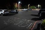 Chalk spells out, “Save our Schools!” in the parking lot of the Dr. Matthew Prophet Education Center.